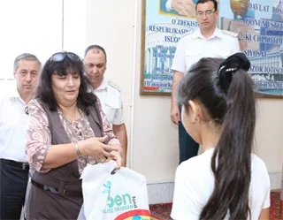 Sen Yolg’iz Emassan hands over school supplies to children